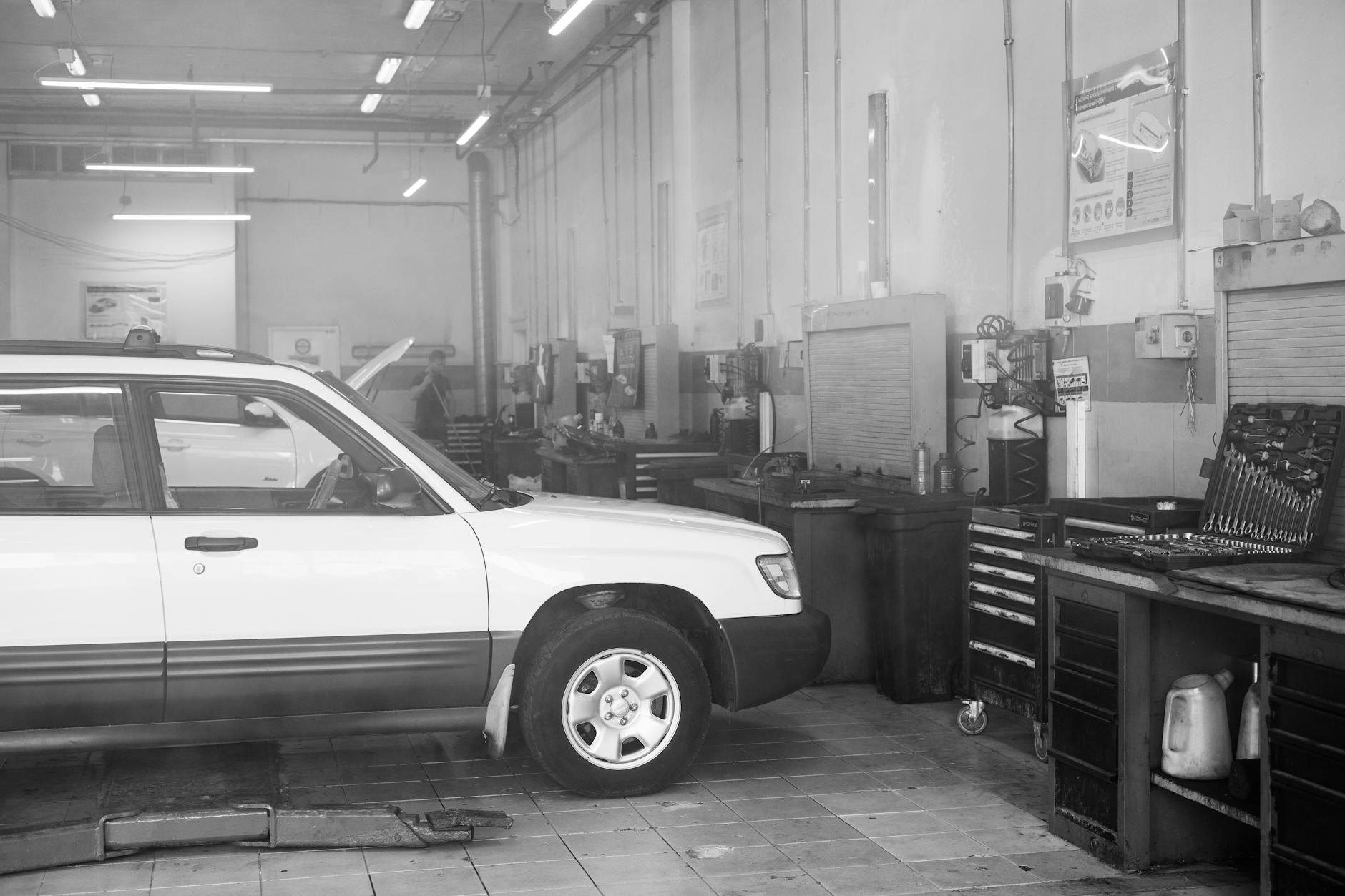 Interior view of auto repair shop with lifted vehicles and diagnostic equipment