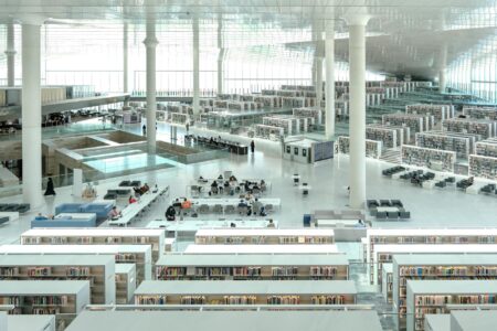 Local Libraries Generate Revenue Through Coworking Space Memberships Modern library interior with tables and chairs arranged for collaborative work