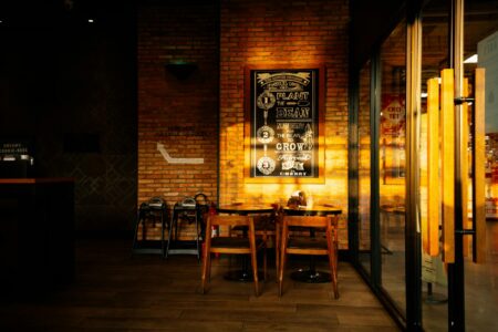 Local Coffee Shops Generate Revenue Through Coworking Day Passes Modern coffee shop interior with tables, chairs, and customers working on laptops