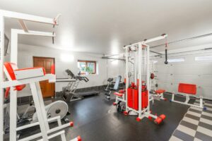 Modern gym interior with exercise equipment and natural lighting during daytime hours