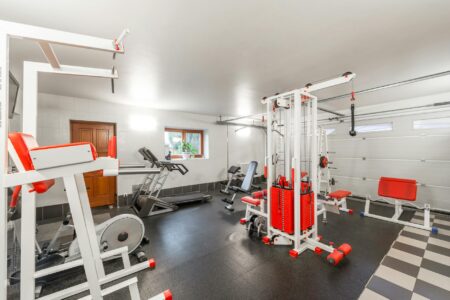 Modern gym interior with exercise equipment and natural lighting during daytime hours