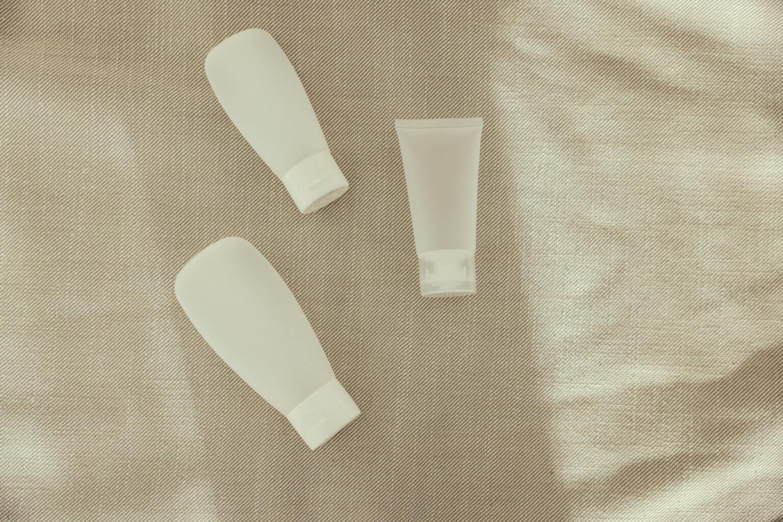 Beauty Industry Giants Report Unexpected Losses as Clean Brands Gain Market Share Various beauty product bottles and containers arranged on white surface