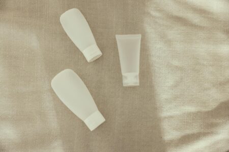 Various beauty product bottles and containers arranged on white surface