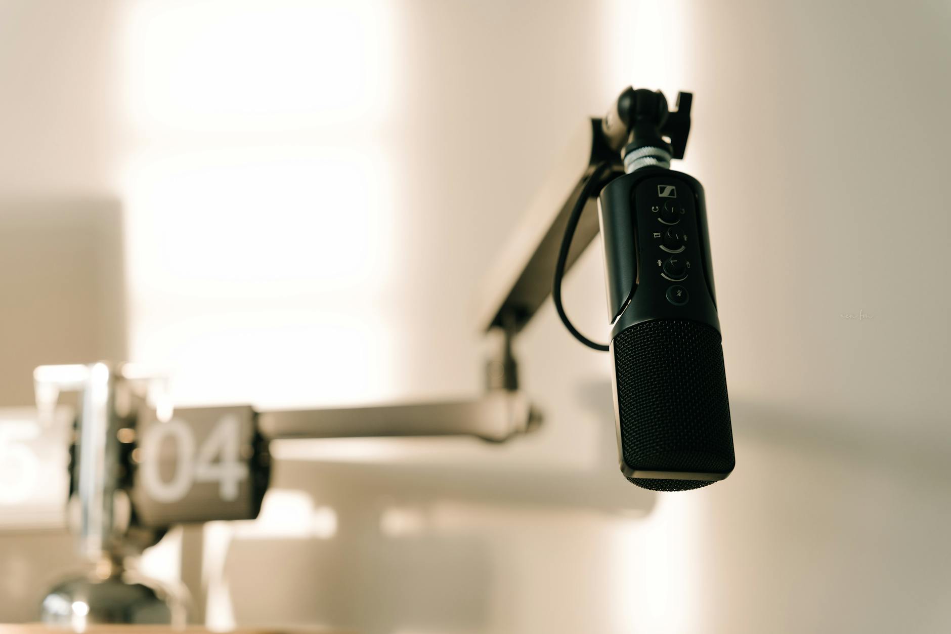 Professional podcast microphone on desk with recording equipment in studio setting