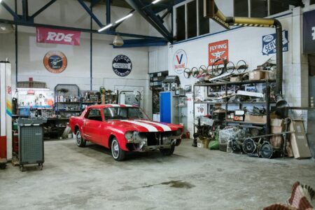 Mechanic working under the hood of a car in an automotive repair shop