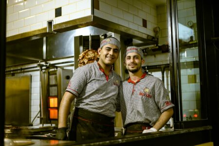 Restaurant kitchen workers preparing food during busy service period