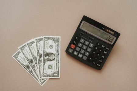 Calculator with dollar bills showing financial planning calculations