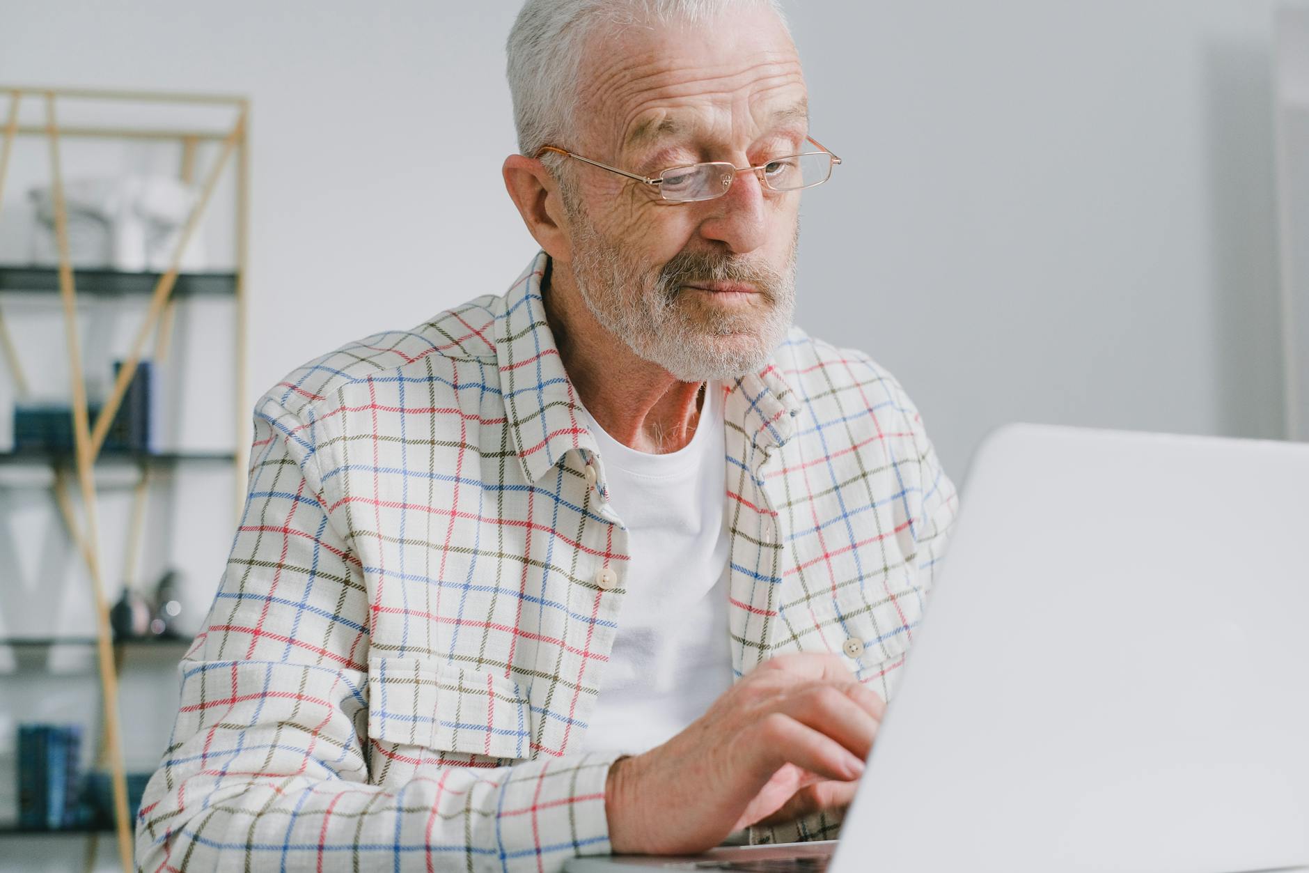 Elderly man using laptop computer for online streaming entertainment