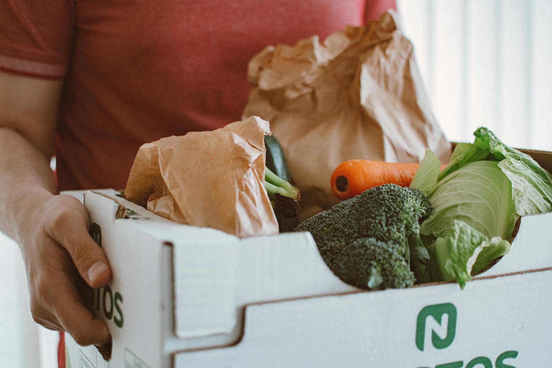 Cardboard delivery box filled with fresh vegetables and produce