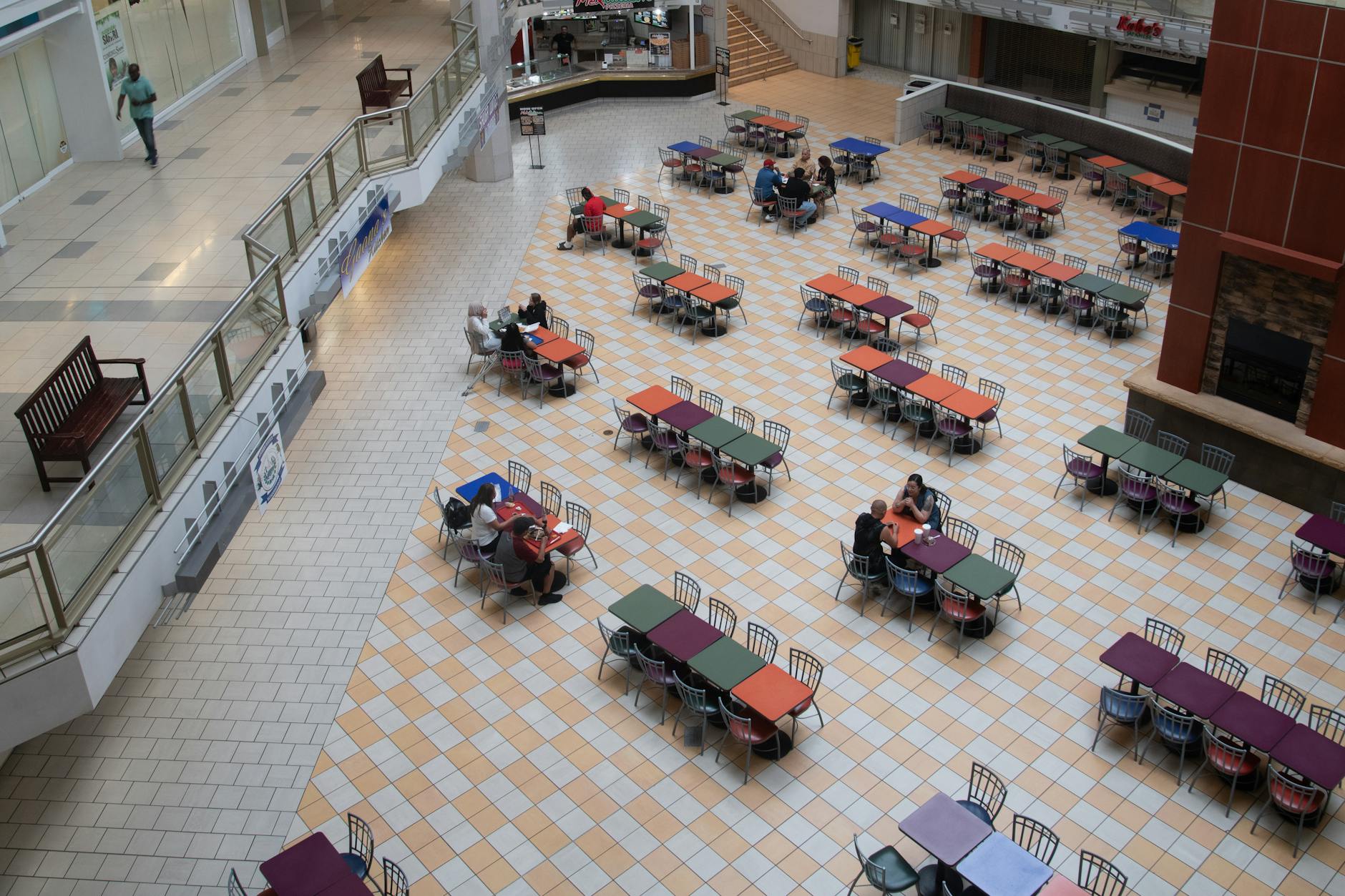 Busy indoor food court with multiple vendor stalls and dining seating