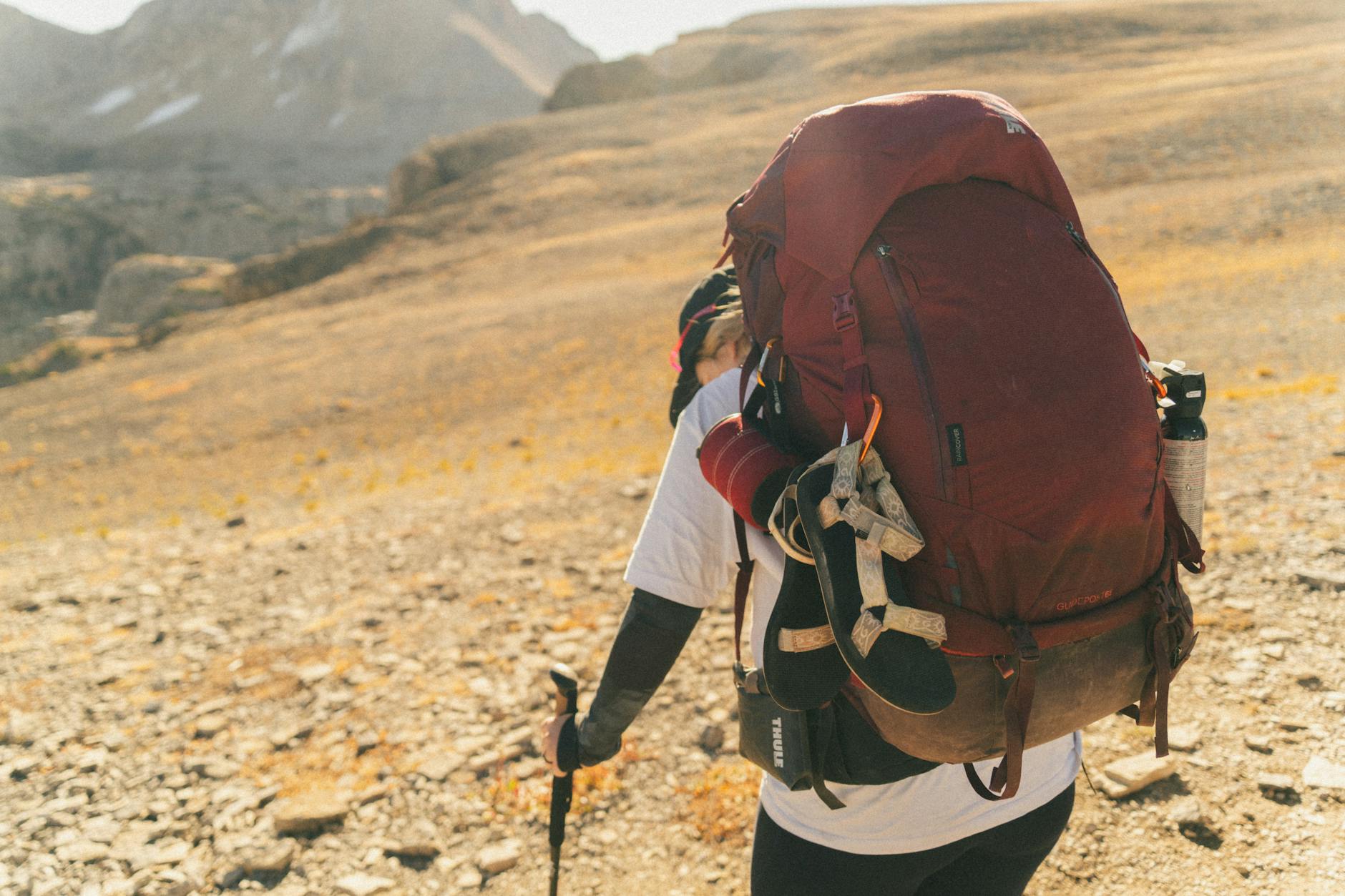 Person hiking on a mountain trail during sabbatical leave, representing work-life balance and personal renewal