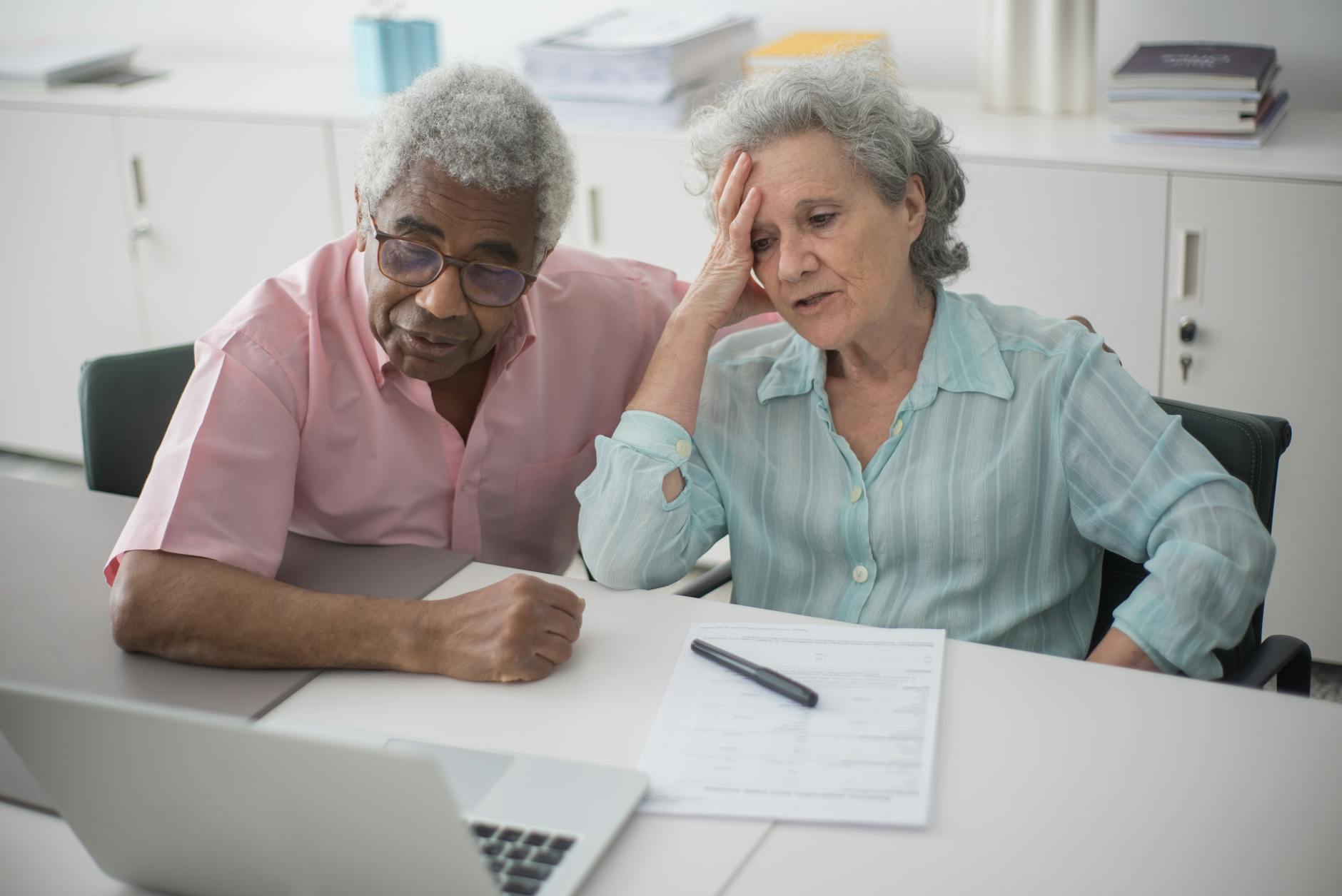 Senior couple reviewing financial documents and retirement planning materials together