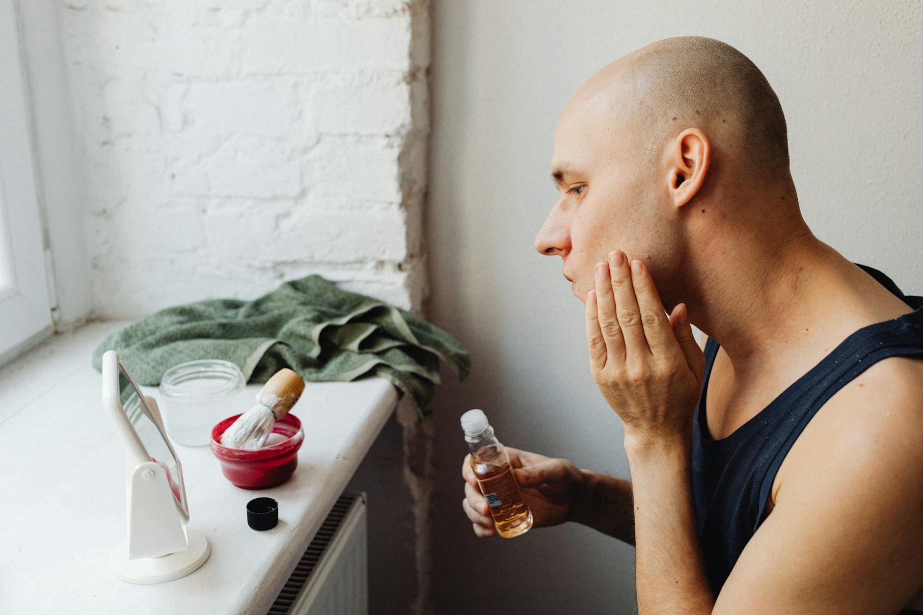 Various men's grooming products including pomade jars and beard oil bottles arranged together