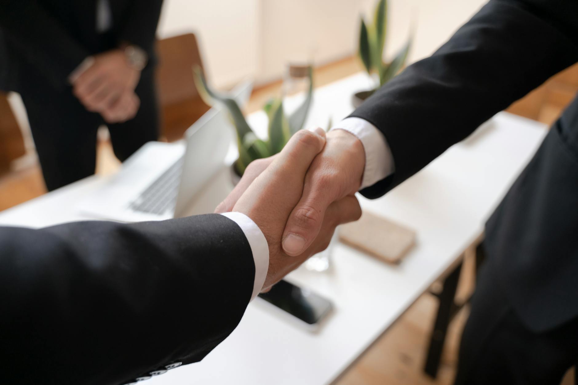 Two business professionals shaking hands in agreement over partnership deal