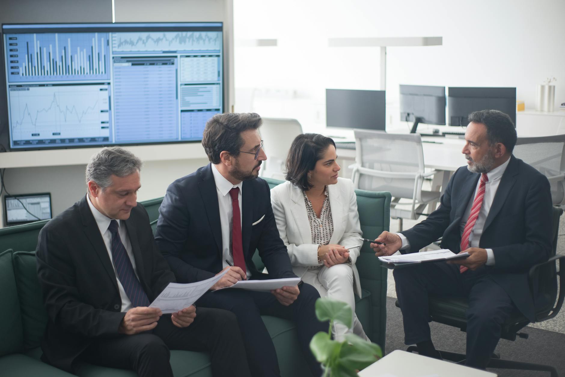 Professional investors reviewing documents and charts in modern office