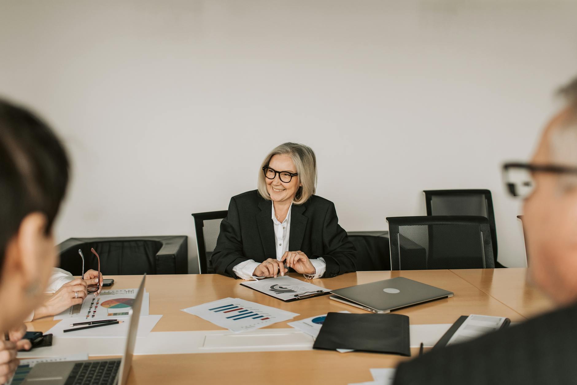 Business executives reviewing financial documents and charts at conference table
