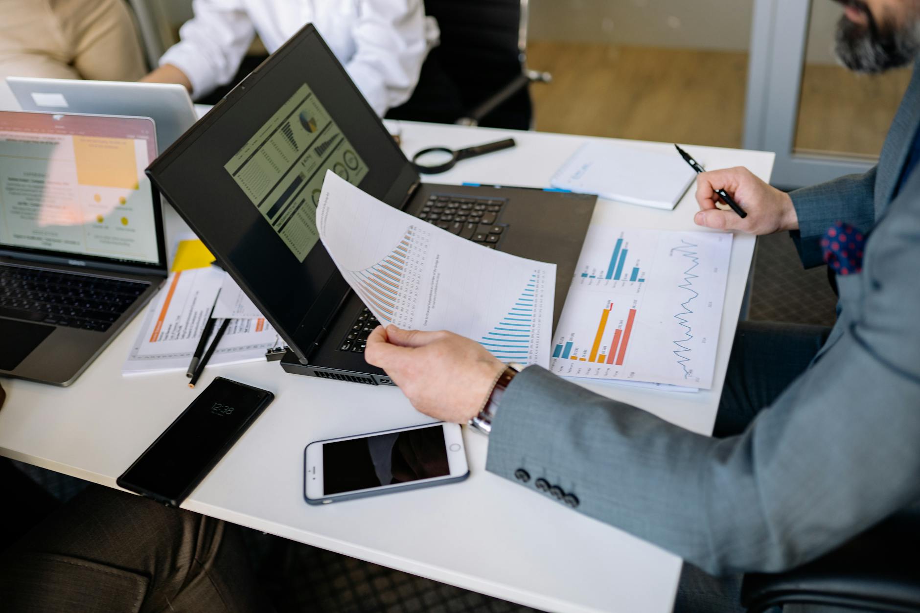 Financial documents and charts on desk during investment planning meeting