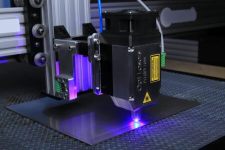 Close-up of a laser engraving machine etching a design onto a wooden surface