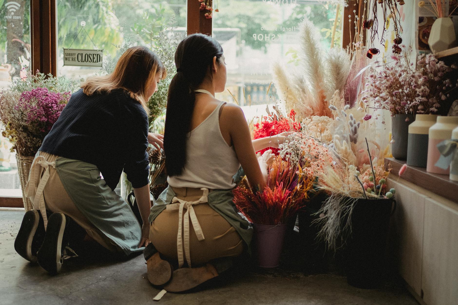 Person's hands working on flower arrangement during educational workshop class