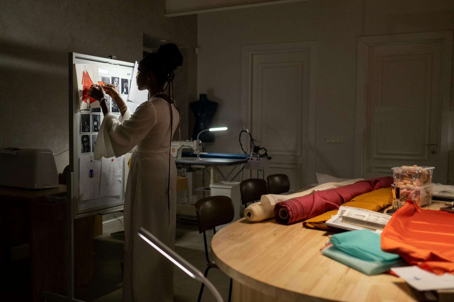 Interior of a tailoring studio with sewing equipment, fabric, and a dressmaking mannequin