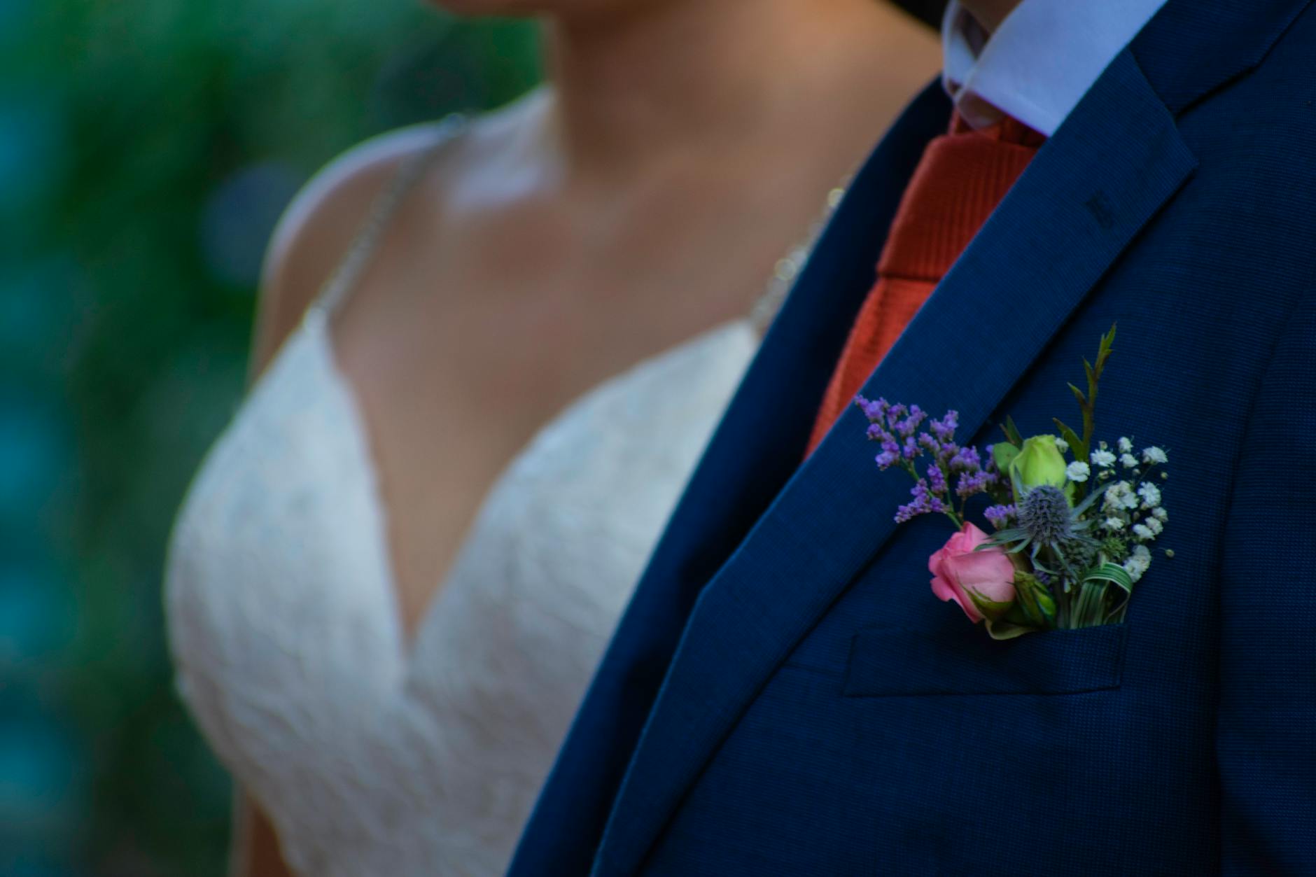 Close-up of delicate lacework and beading on a white wedding gown during a fitting