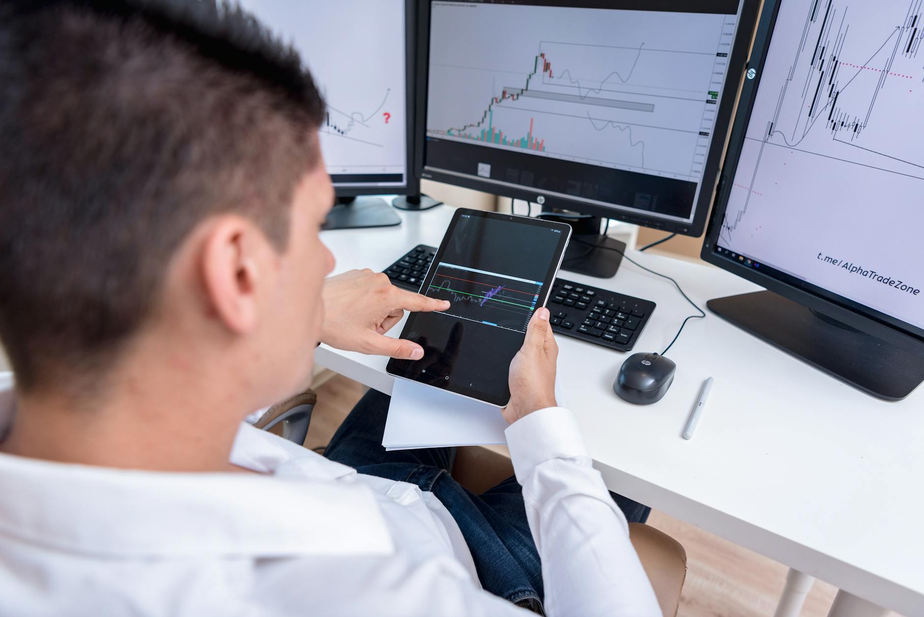 Investor reviewing financial documents and considering portfolio decisions at a desk