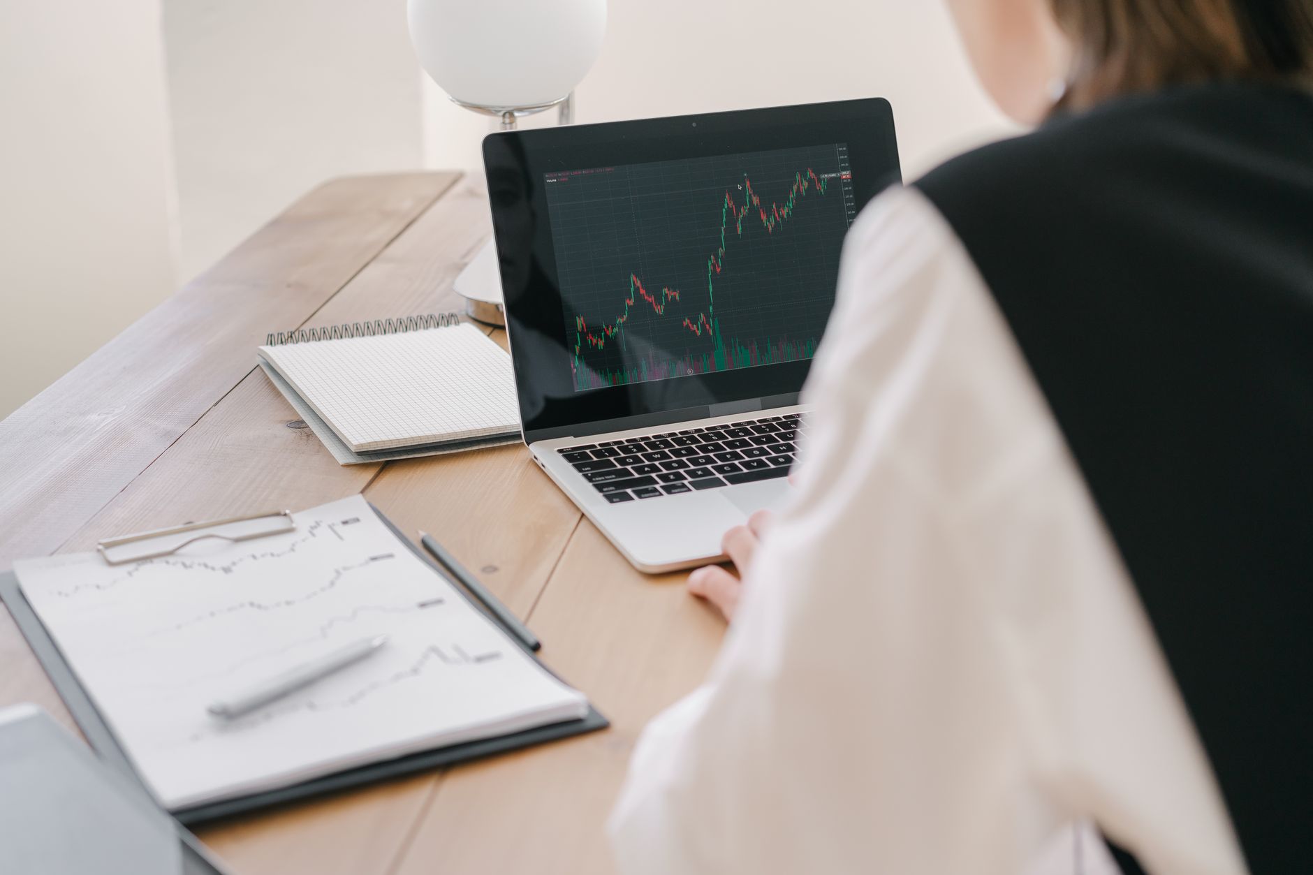 Financial analyst reviewing ETF portfolio data at a desk with multiple screens