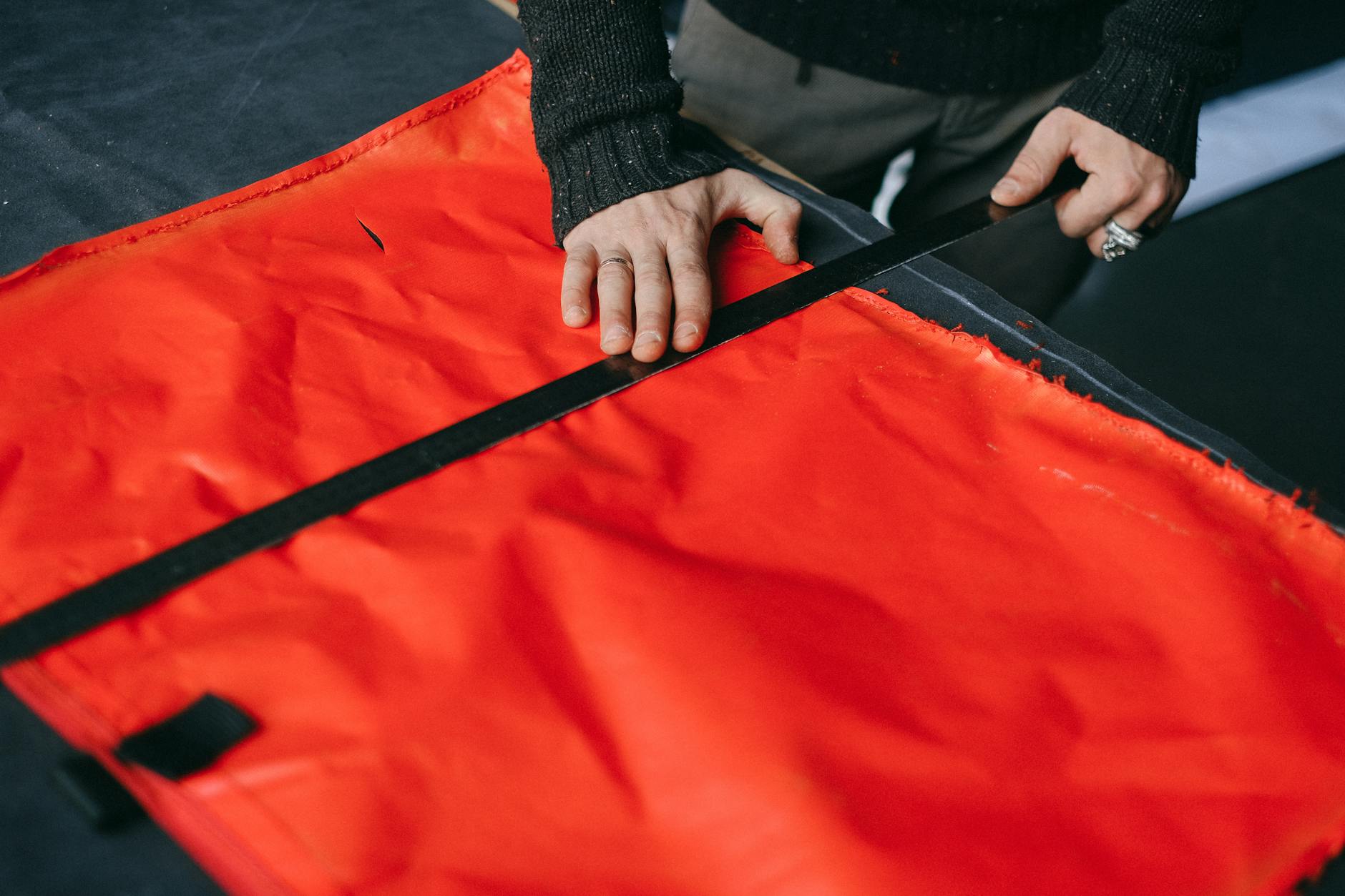 Professional seamstress measuring fabric for clothing alteration work