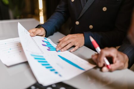 Investor reviewing portfolio documents at a desk, representing interval fund research