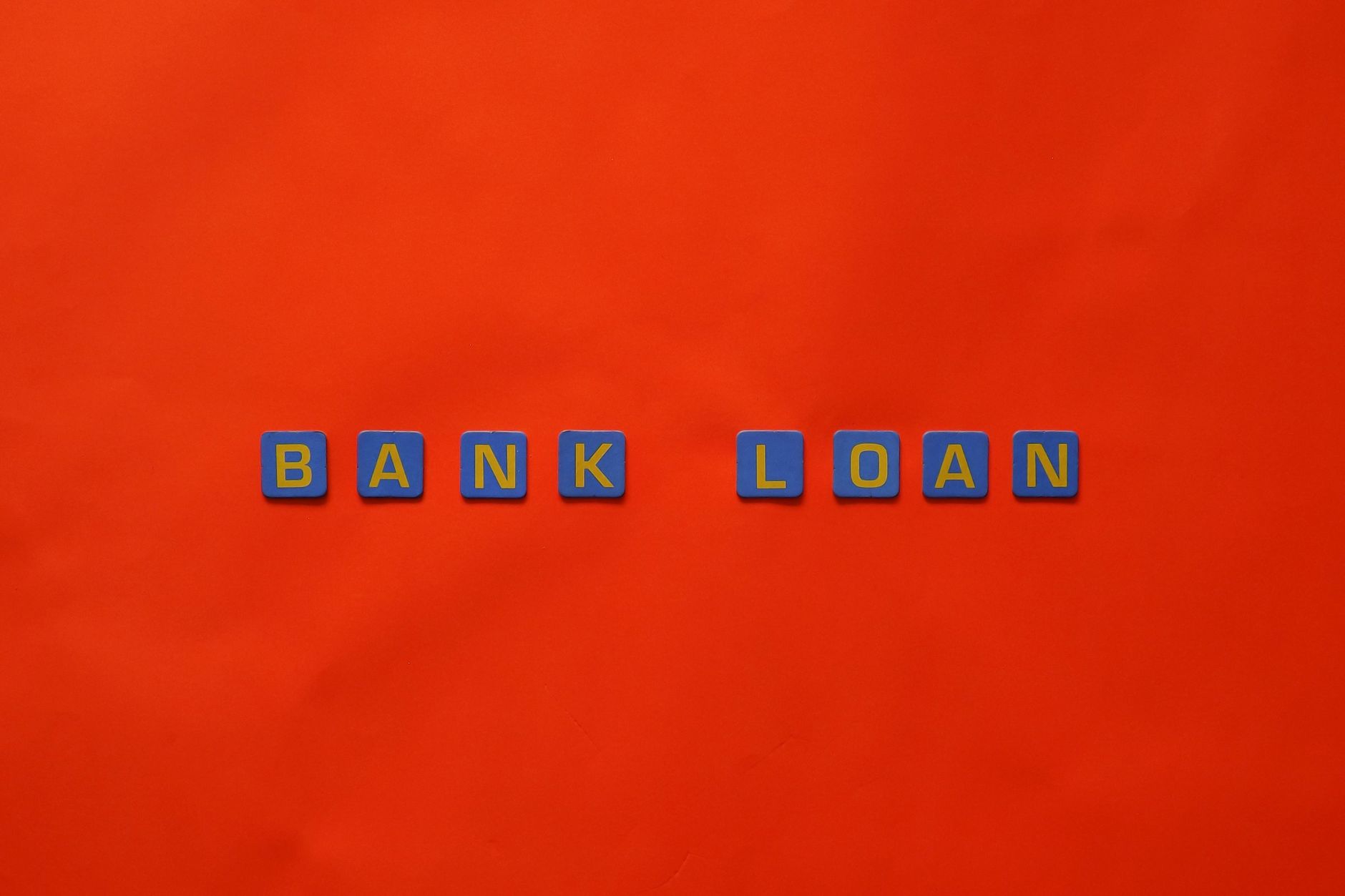 Business professionals reviewing a loan agreement document with financial charts nearby