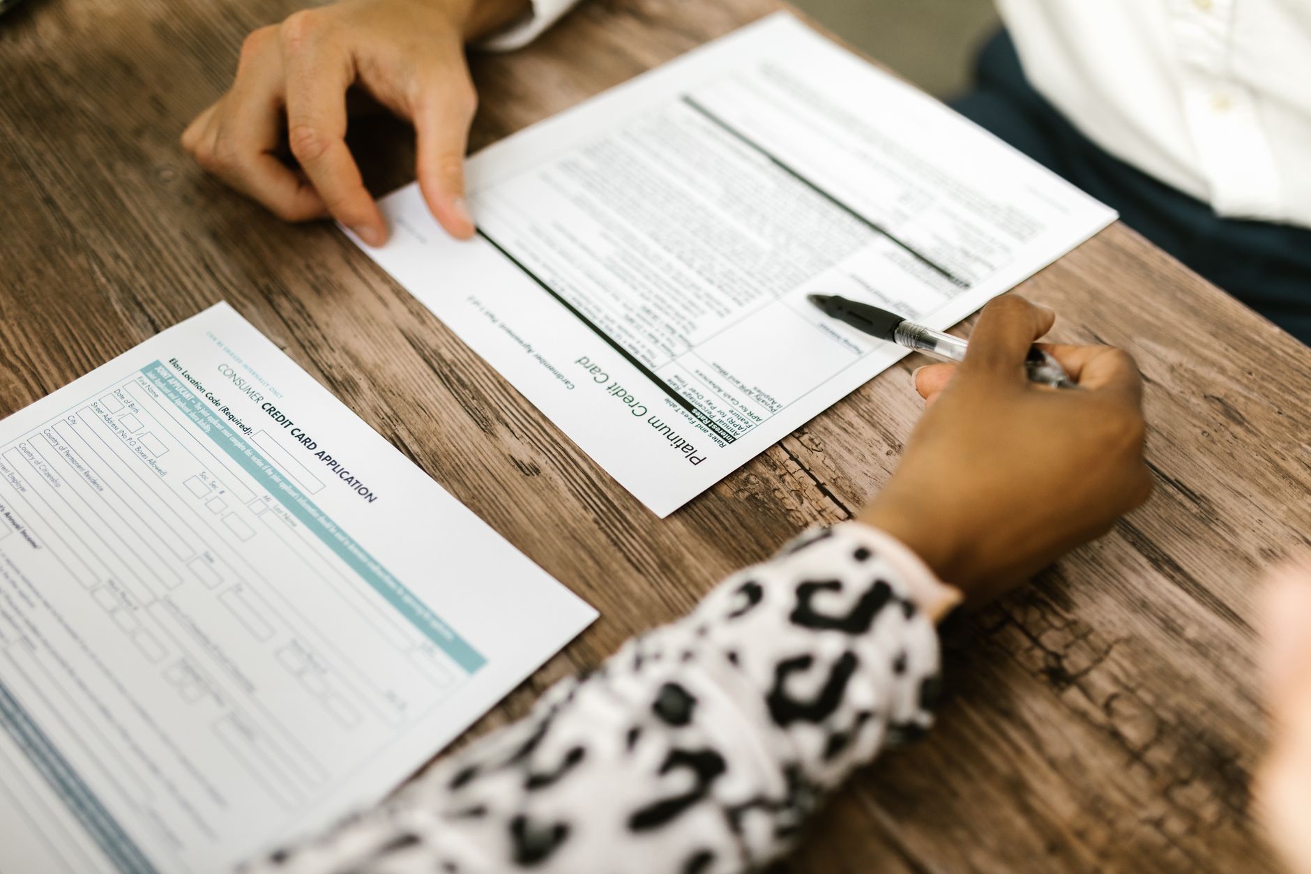 Person reviewing and signing a formal lending or credit agreement document