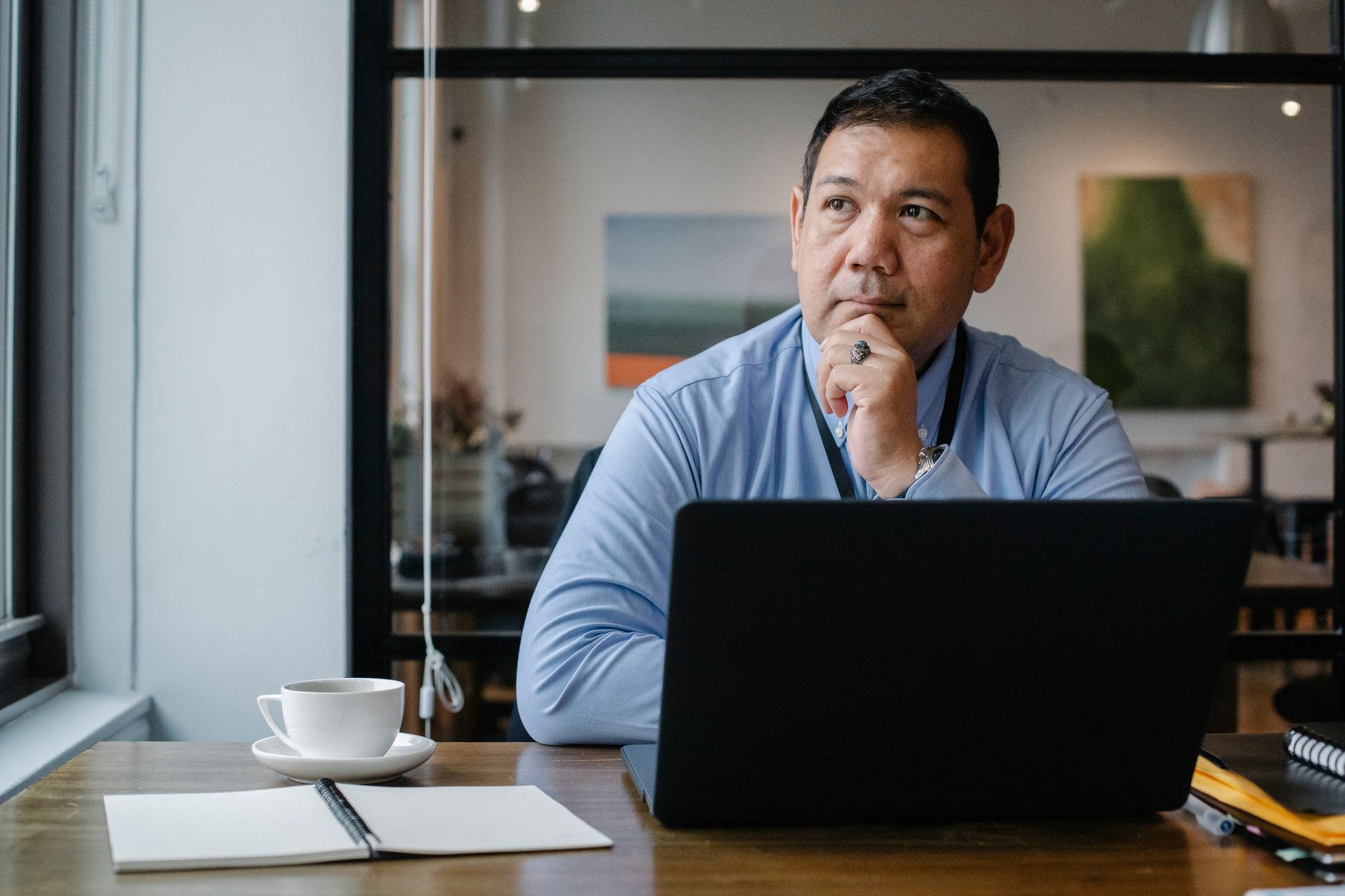 Investor reviewing documents and considering investment decisions at an office desk