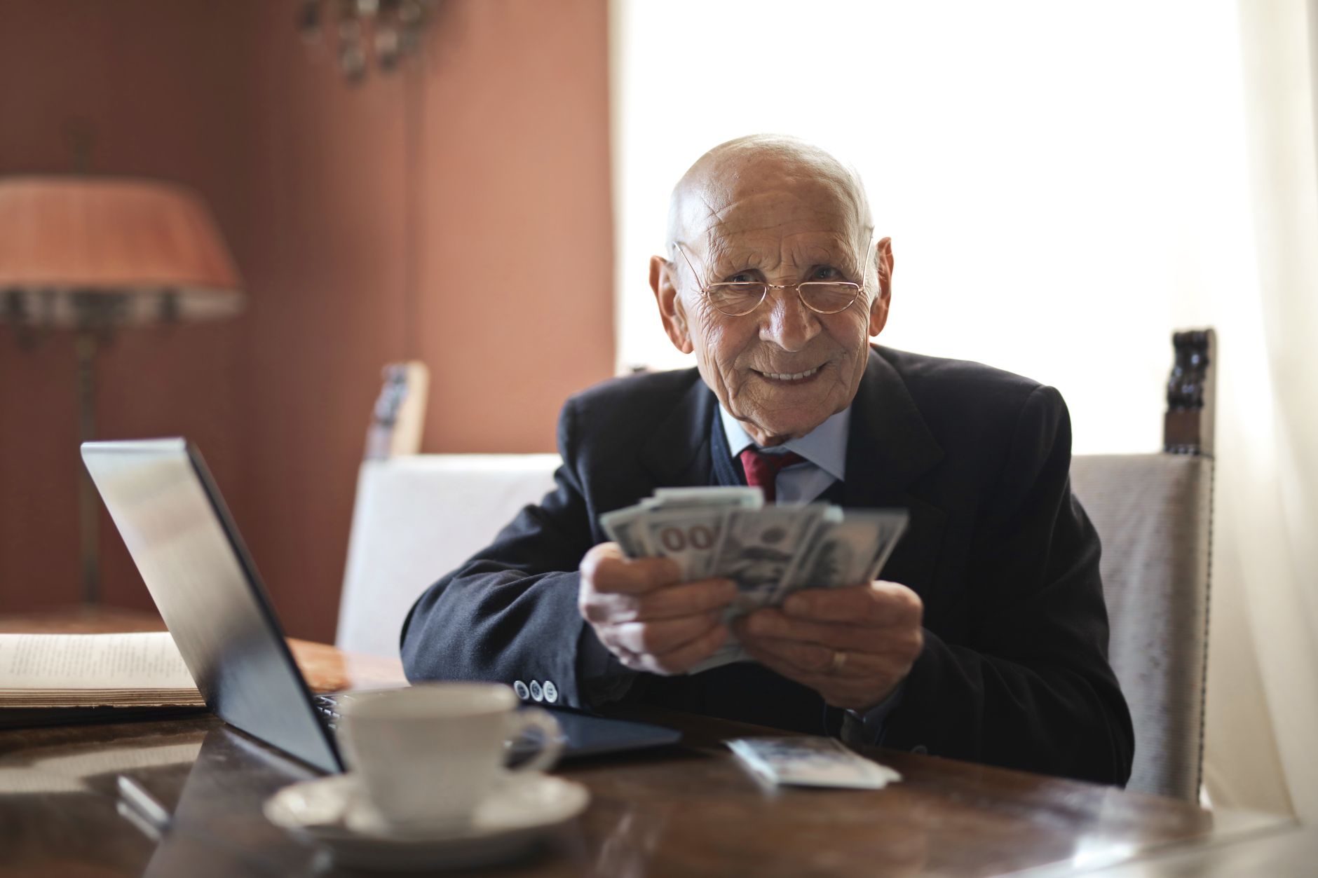 Older man reviewing investment portfolio on a laptop at home