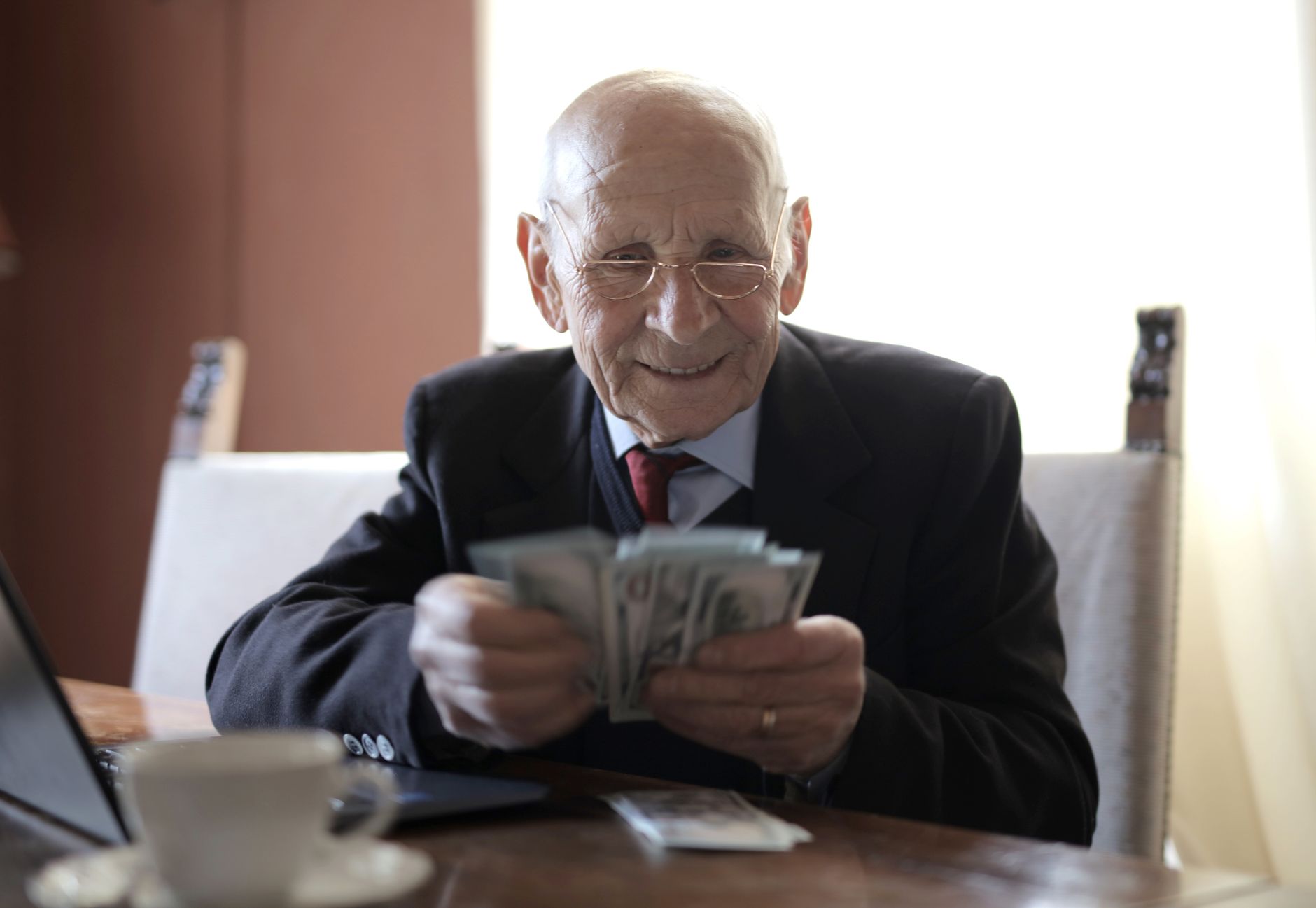 Senior man reviewing investment portfolio on a laptop at home