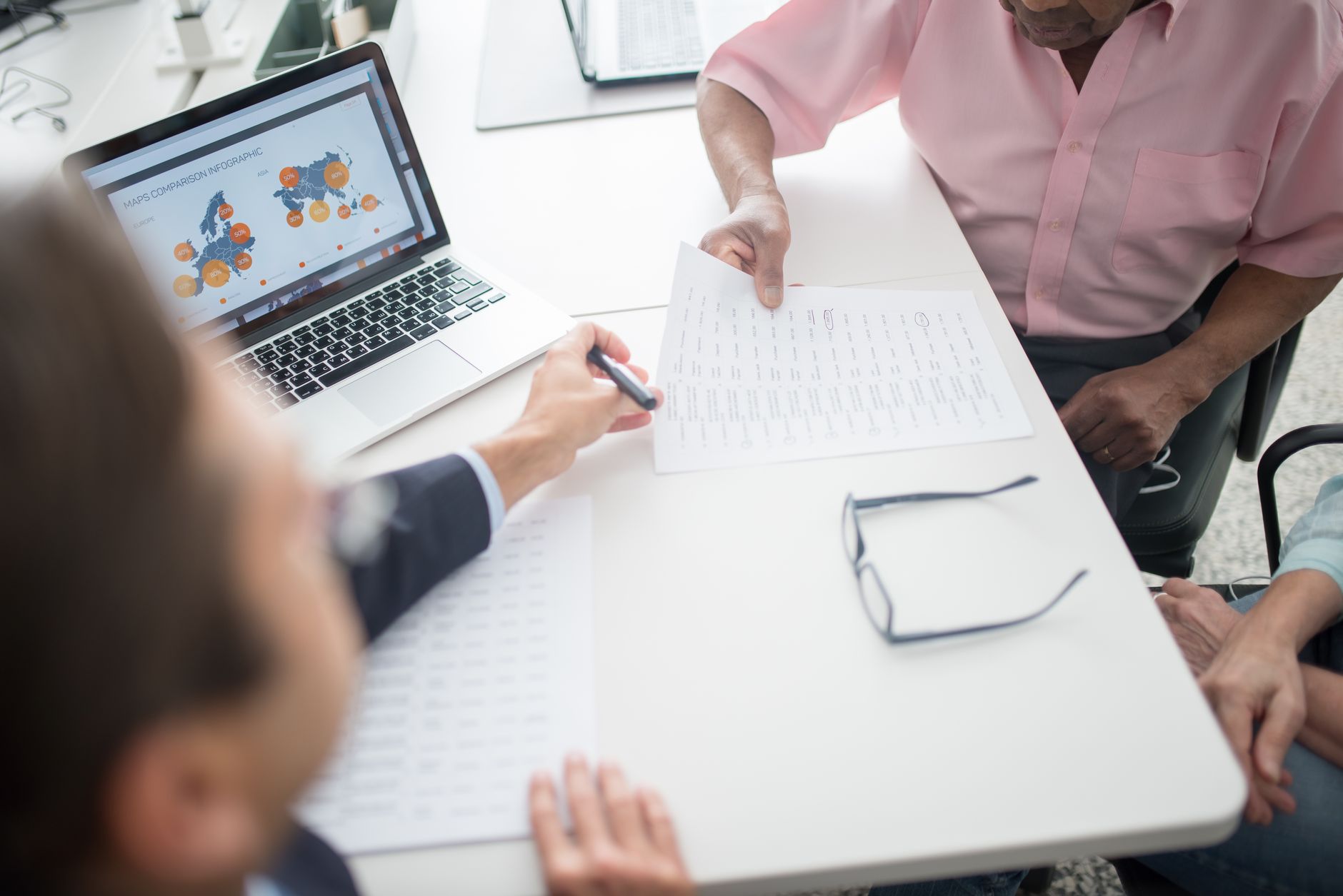 Two people reviewing financial documents at a table during a retirement planning session