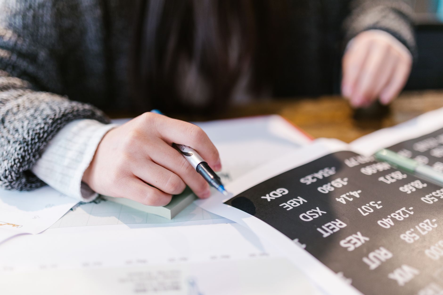 Individual investor calculating long-term bond returns at a desk with financial documents