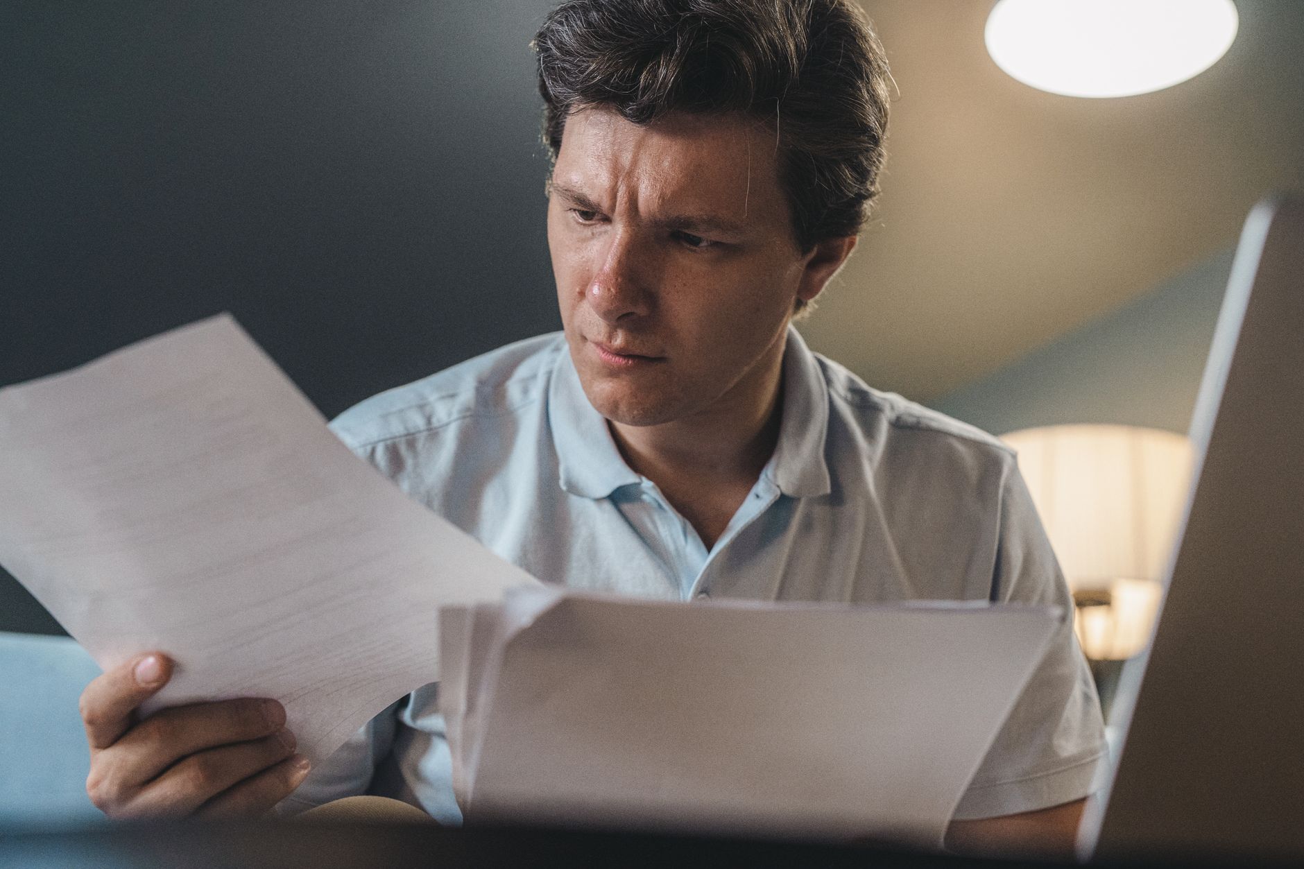 An investor reading financial paperwork and fund documents at a desk