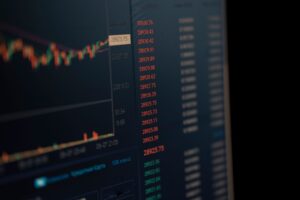 Trader monitoring currency exchange rates on multiple screens