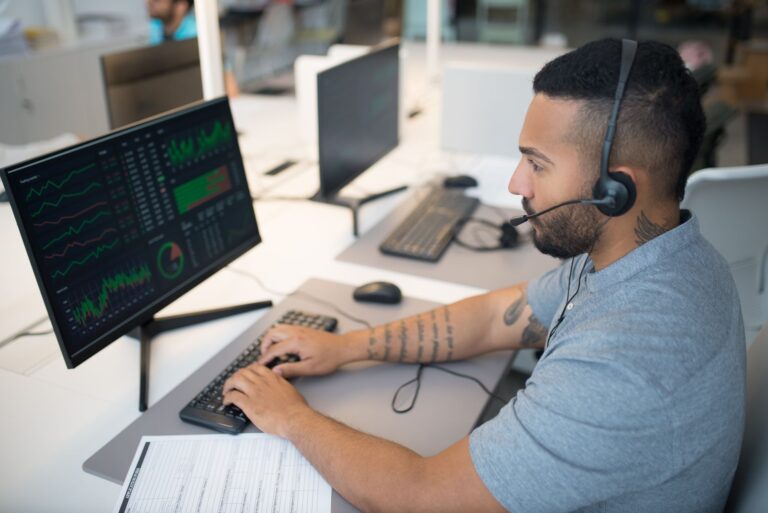 Traders working at desks in a busy financial trading environment