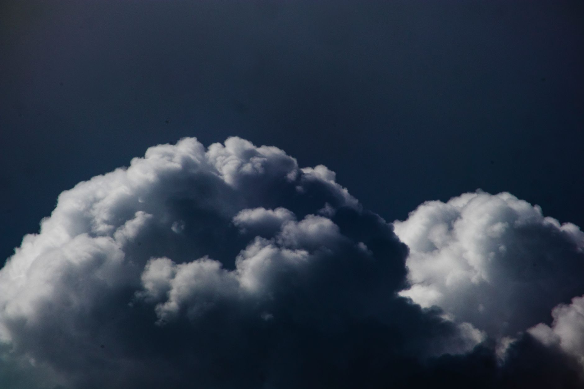Dark storm clouds viewed from above representing catastrophe risk in reinsurance markets