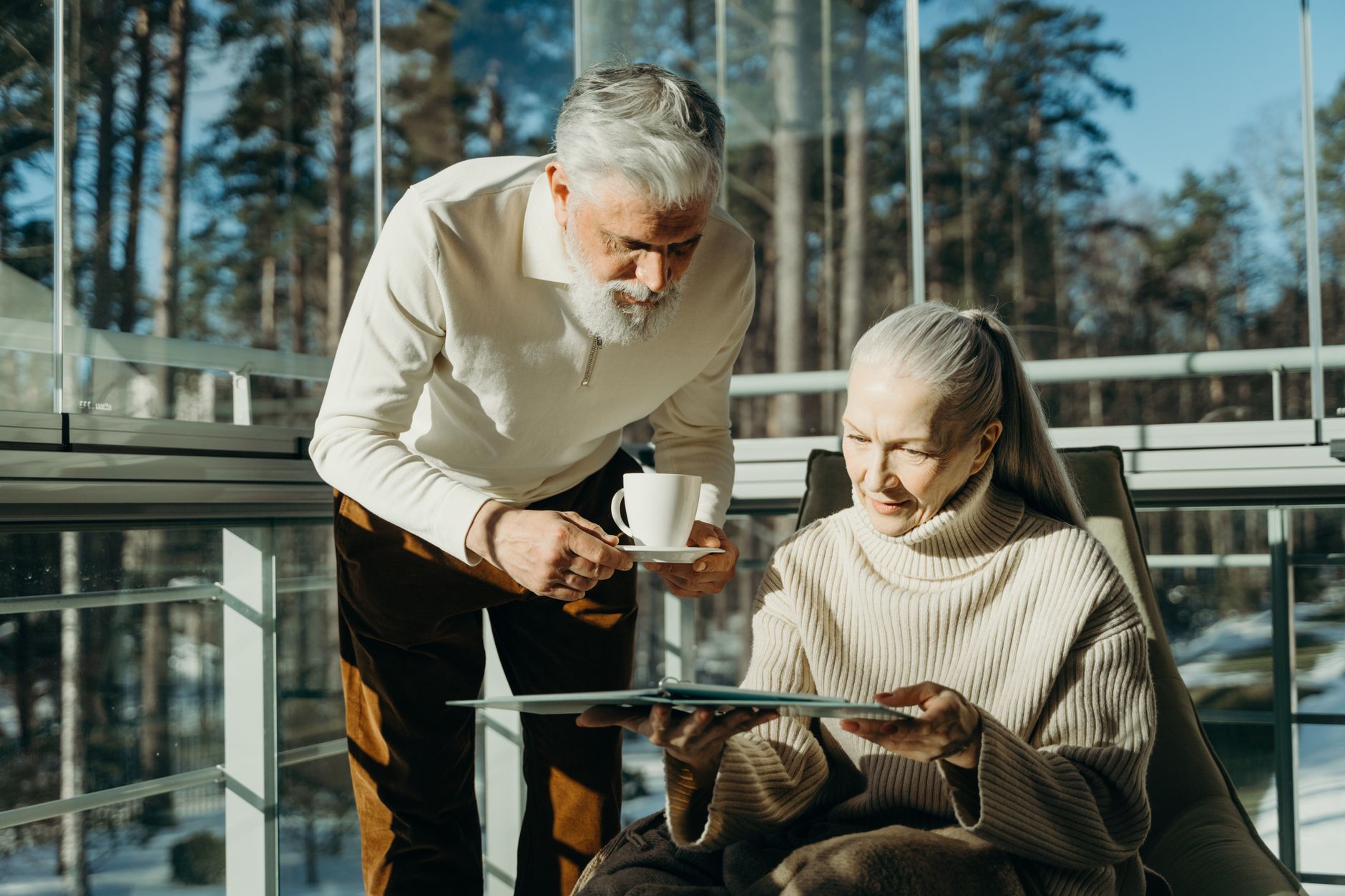 A retired couple reviewing investment documents at a kitchen table