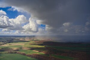 Dark storm clouds viewed from above, representing natural disaster risk in catastrophe bond investing