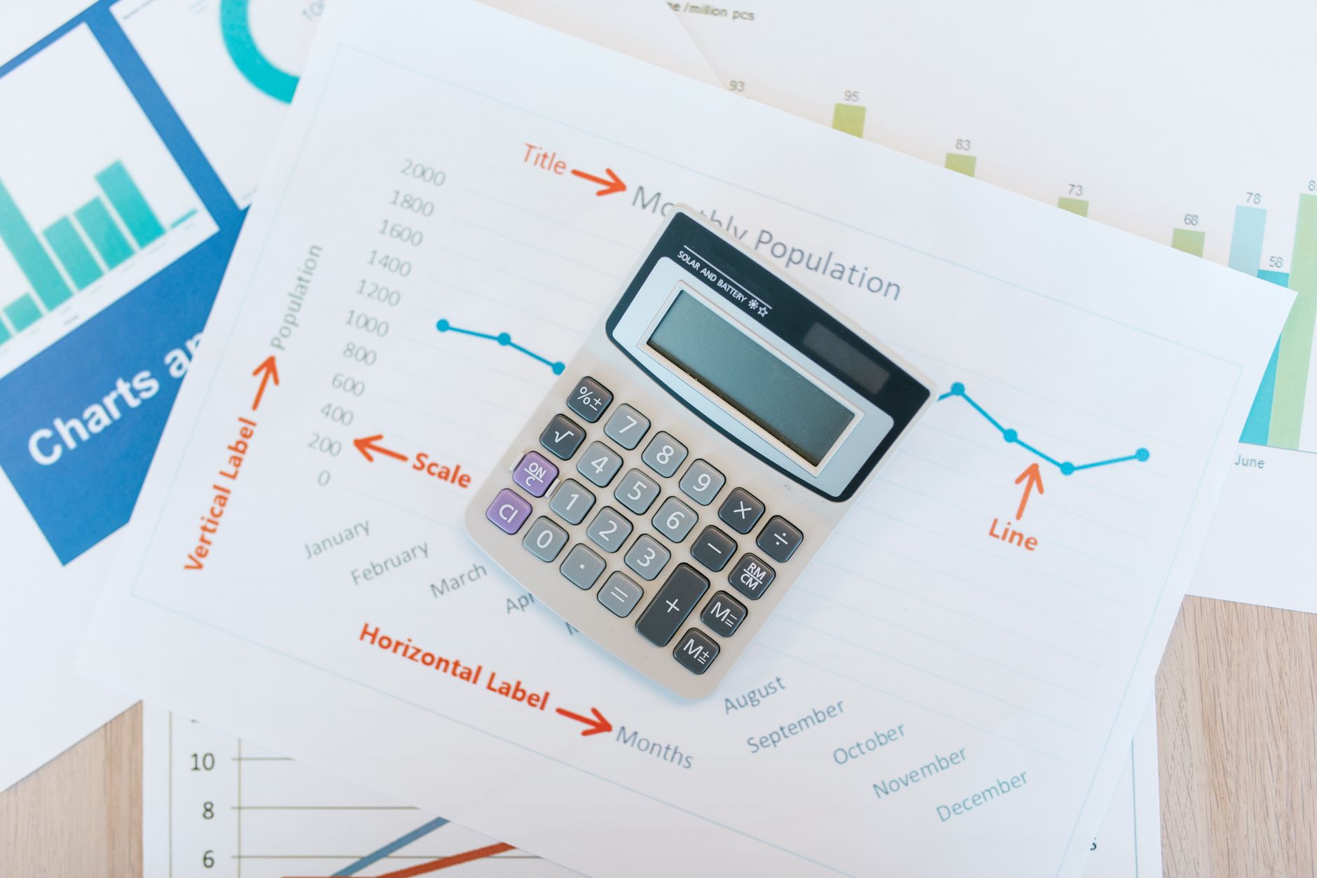 Financial analyst reviewing credit portfolio charts on a desk with multiple screens