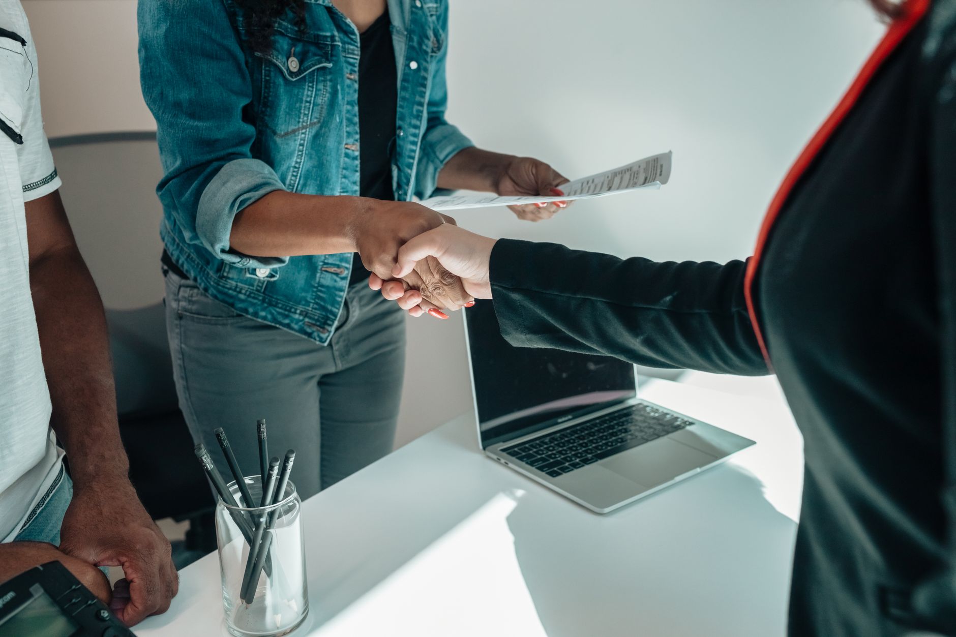 Two business professionals shaking hands in a corporate setting representing shareholder agreements