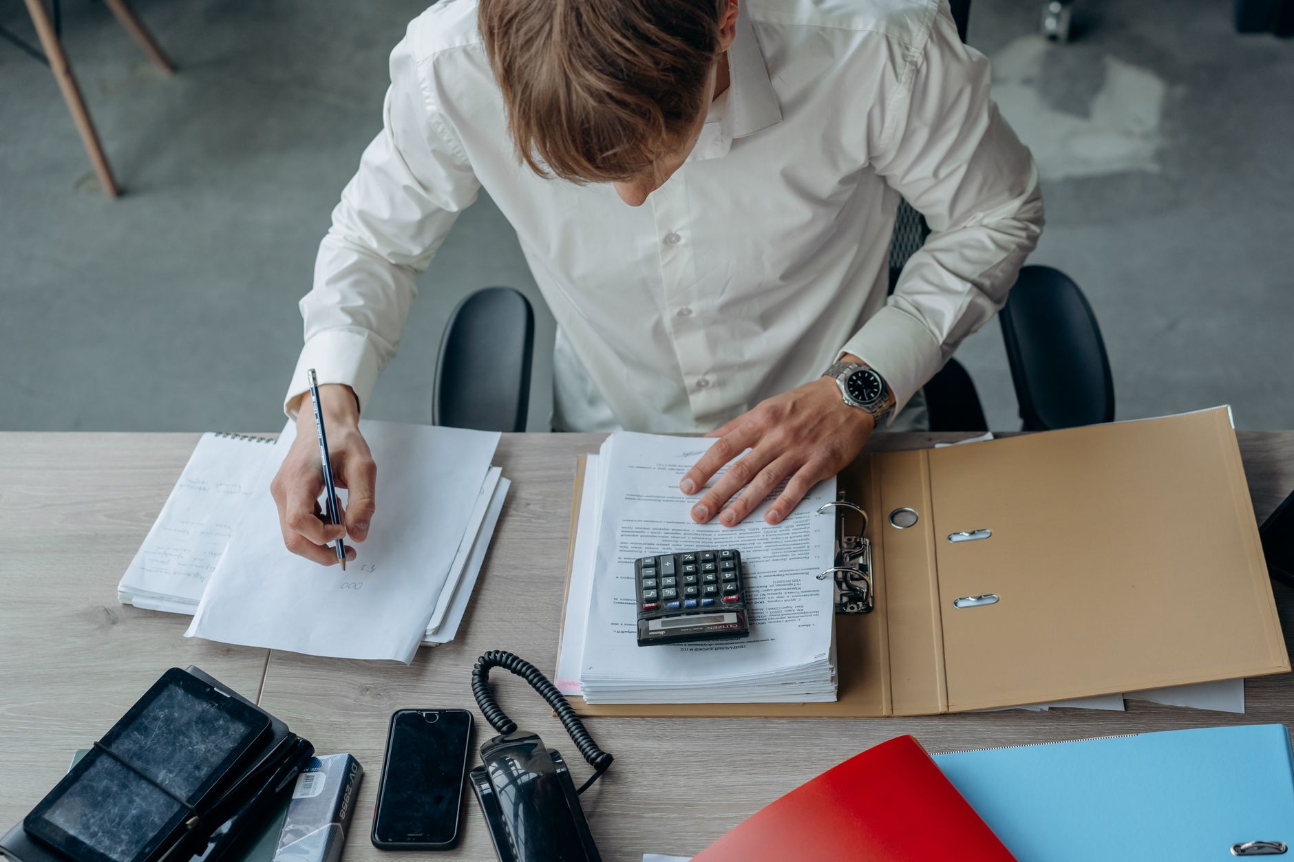 Business professional reviewing financial documents and fund performance reports at a desk