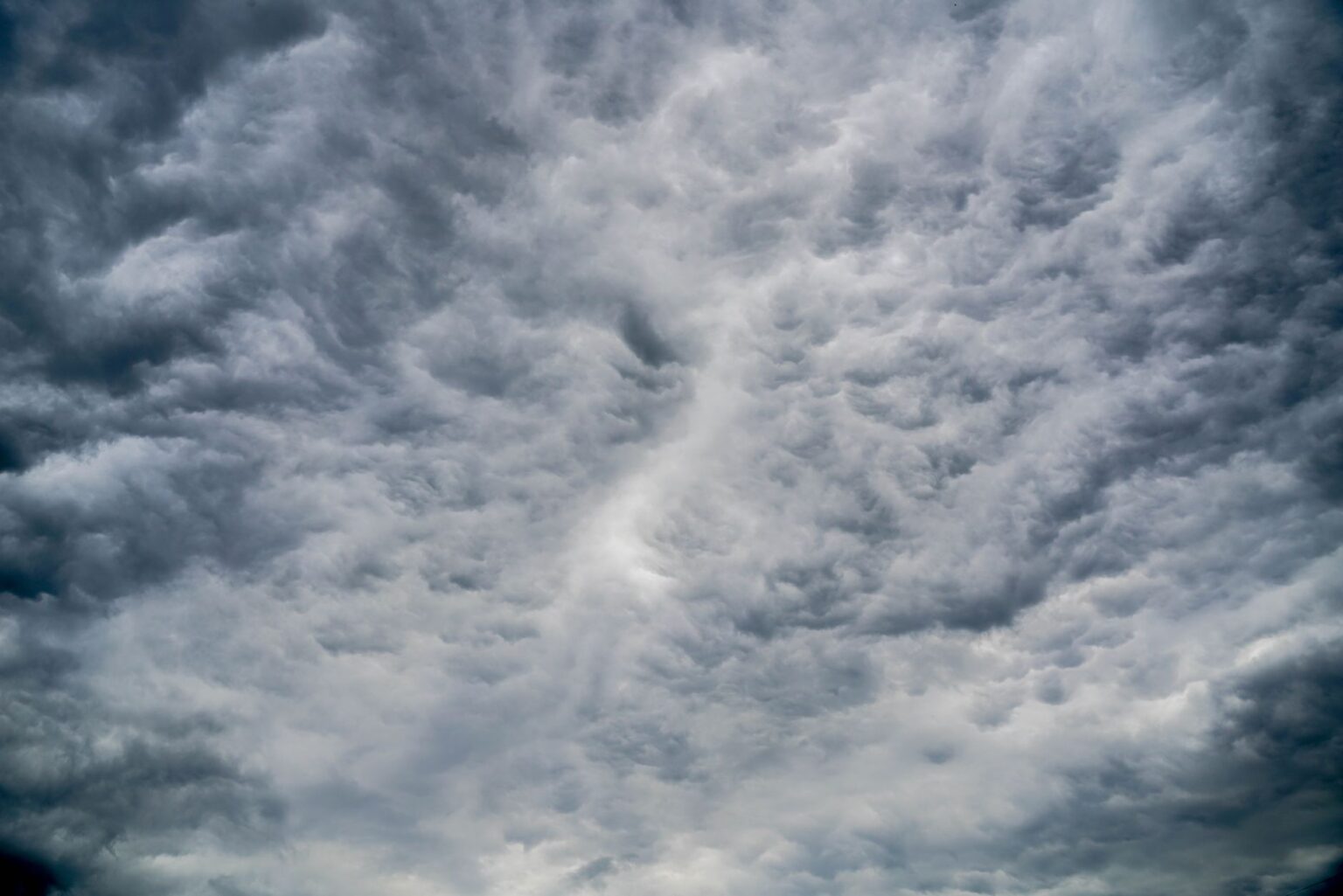 Reinsurance Sidecars Quietly Draw Family Office Capital as CAT Losses Mount Aerial view of dark storm clouds forming over open landscape, representing catastrophe weather risk