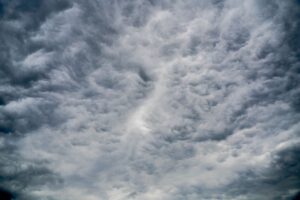 Reinsurance Sidecars Quietly Draw Family Office Capital as CAT Losses Mount Aerial view of dark storm clouds forming over open landscape, representing catastrophe weather risk