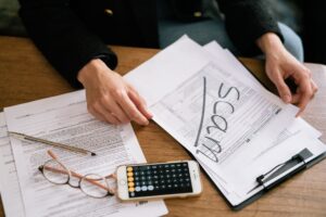 Tax documents and financial paperwork spread across a desk representing after-tax investment calculations
