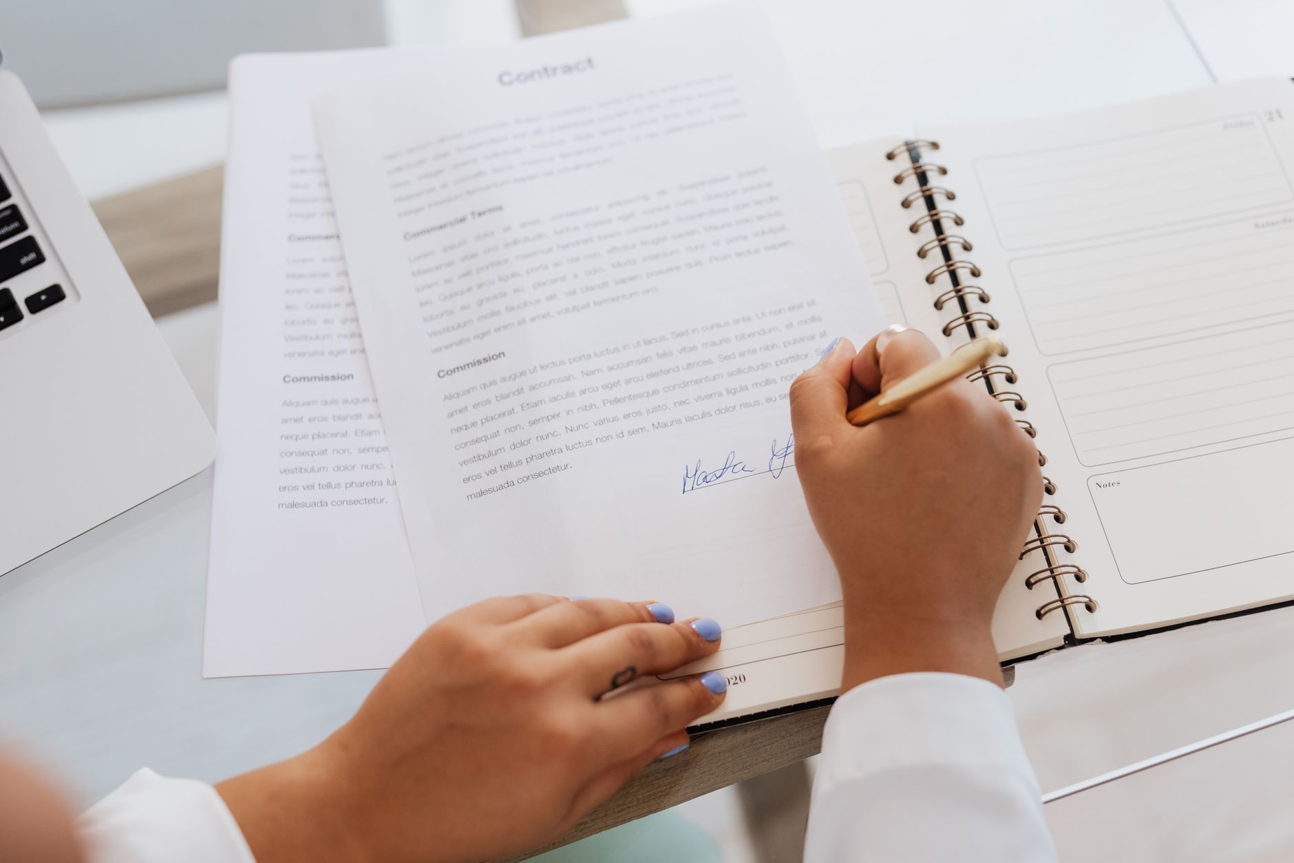 Two professionals signing a financial contract at a desk, representing royalty streaming agreements