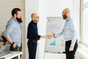 Two professionals shaking hands over a financial agreement representing private credit transactions
